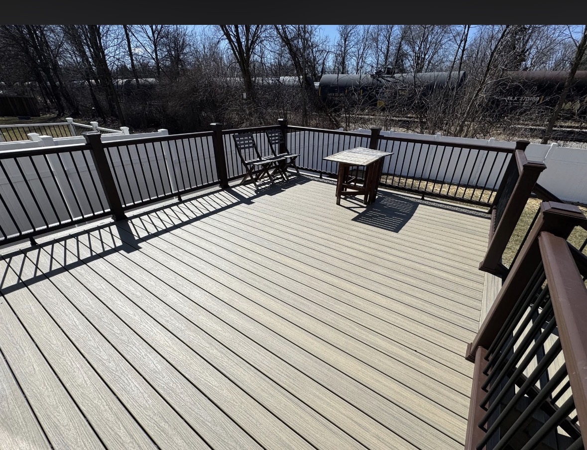 Composite deck with black metal railing, bistro table and chairs