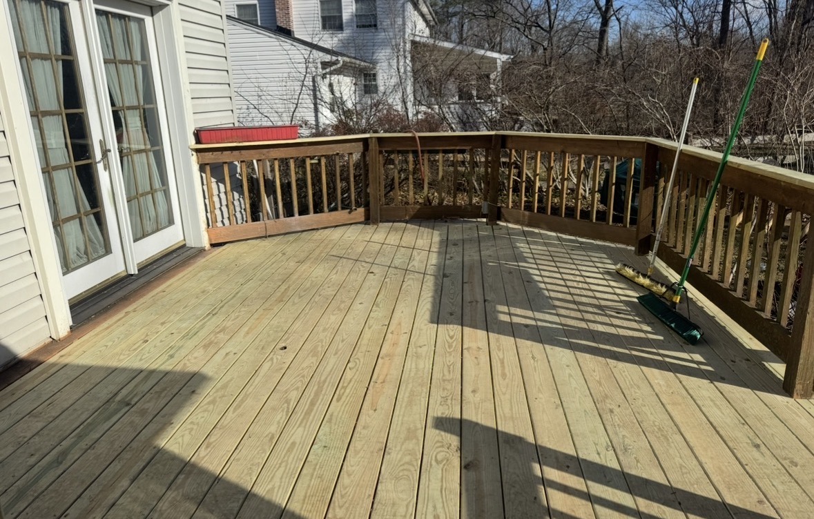 Worn weathered wood deck with aging railing before replacement